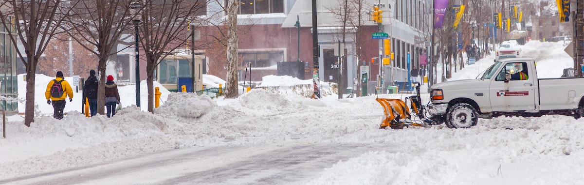 truck on road with snow plow attachment